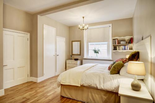 什鲁斯伯里Ludwick Apartment的一间卧室配有一张带灯和窗户的床