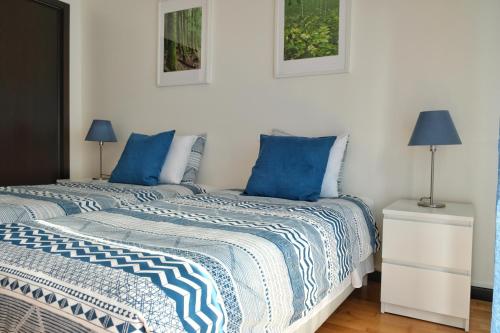 卡佩拉什Capelas Garden的白色客房内的两张床和蓝色枕头