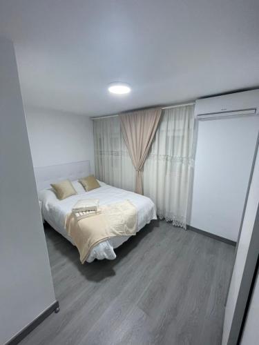 托雷洪-德阿尔多斯Tu precioso piso en el centro de Torrejón的一间小卧室,配有床和窗户