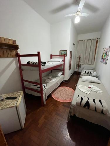 桑托斯Pousada São Marcos的客房设有三张双层床和天花板。