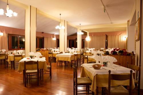 Prati di TivoHotel Gran Sasso的餐厅配有桌椅和白色的桌布