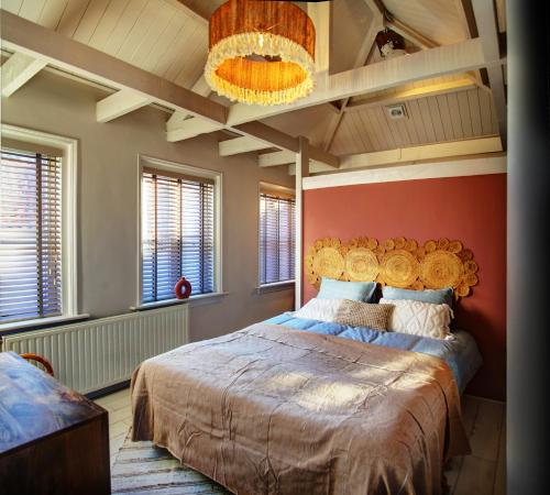 托伦Villa Azura的一间卧室设有一张红色墙壁的大床