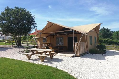 阿尔科巴萨Silver Coast Glamping luxury lodge的帐篷配有野餐桌和长凳