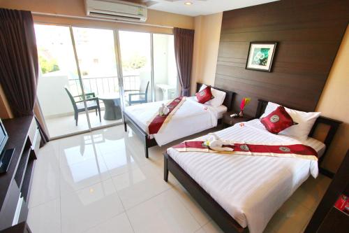 乔木提恩海滩Valhalla Pattaya的酒店客房设有两张床和一个阳台。