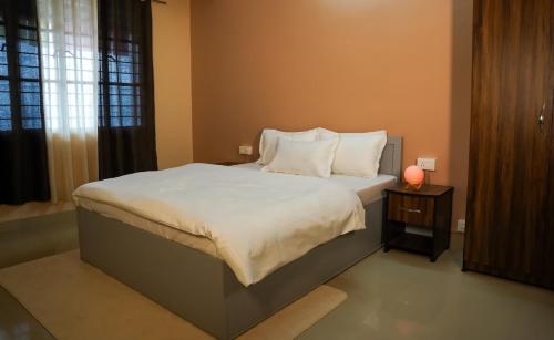 甘托克Yellow Sapphire, Premium Sikkimese Homestay的卧室配有一张带白色床单和枕头的大床。