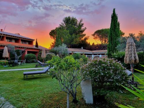 莫桑莱阿尔皮莱卡斯蒂巴克斯酒店的一个带长凳和树木的花园以及一座建筑