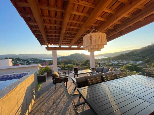 巴耶德布拉沃LUXO Casa en Valle de Bravo con jacuzzi y espectacular vista al lago的屋顶上带桌椅的天井