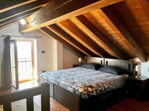 ValbravennaAgriturismo Cascina Clavarezza的一间卧室设有一张带木制天花板的大床