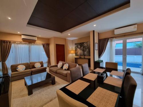 乔木提恩海滩Midas Pool Villa的带沙发的客厅和用餐室