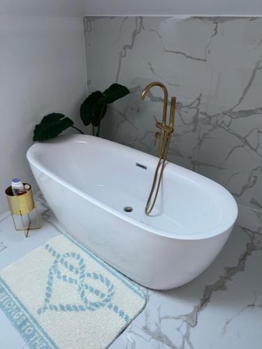 Gladna MontanăCasa Dea的浴室设有白色浴缸,拥有大理石墙壁。