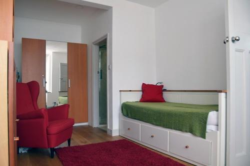 雷德布里奇5 bedroom sunlit family house with garden的一间卧室配有一张床和一张红色椅子