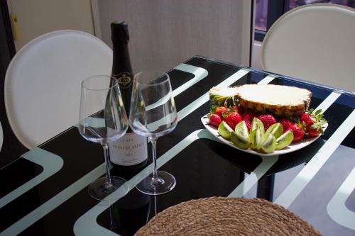 贝尼多姆LUXURY Residence Gemelos 26的一张桌子,上面放有一盘水果和酒杯