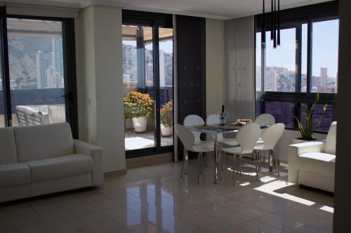 贝尼多姆LUXURY Residence Gemelos 26的客厅设有餐桌和椅子