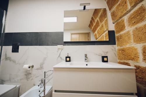 布林迪西La conigliera的一间带水槽和镜子的浴室