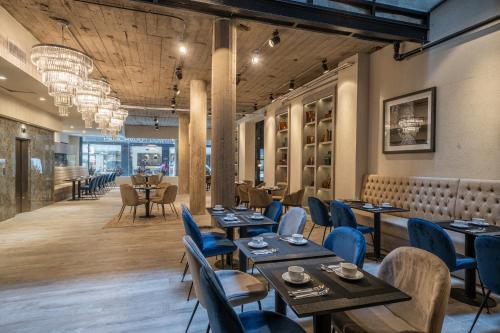 布宜诺斯艾利斯Efe Hotel & Cowork的餐厅设有木桌和蓝色椅子