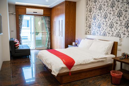 宜兰市宜蘭 星居 包層公寓的卧室配有床、椅子和窗户。