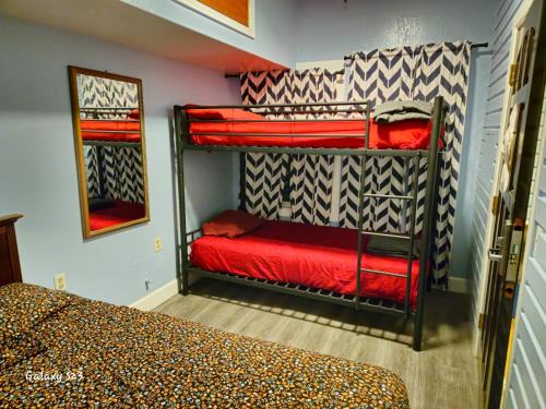 旧金山欧洲招待酒店的一间卧室配有两张双层床,铺有红色床单