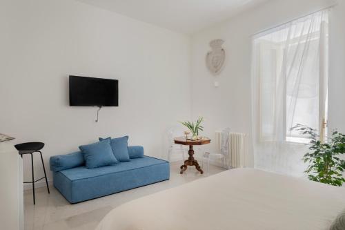 巴勒莫Palazzo Ventimiglia的客厅配有蓝色的沙发和电视