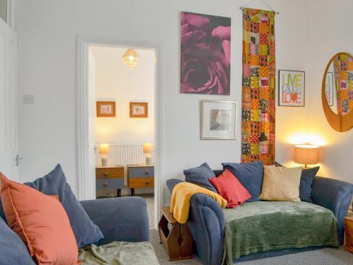 布里德灵顿Brincliffe Landing - Uk42799的客厅配有蓝色沙发及色彩缤纷的枕头