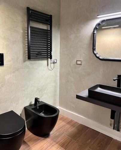 莱切Alèa Rooms的浴室设有黑色的卫生间和水槽。
