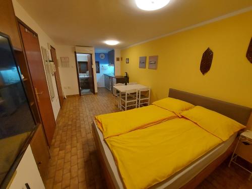 皮兰特拉公寓的黄色卧室配有床和桌子