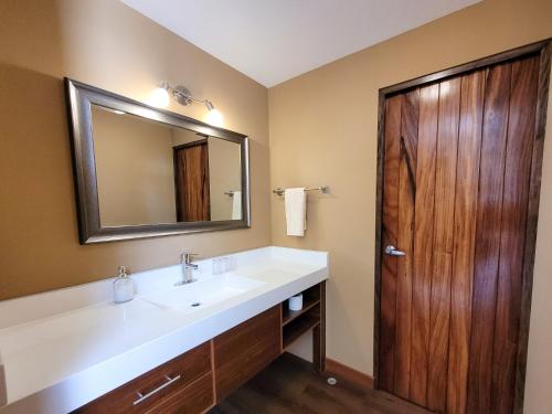 危地马拉Apartamentos 649的一间带水槽和镜子的浴室以及一扇木门