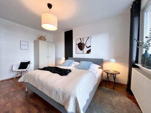 伍珀塔尔SABE APARTMENT: BALCONY + FREE PARKING + NETFLIX的一间卧室配有带白色床单和蓝色枕头的床。