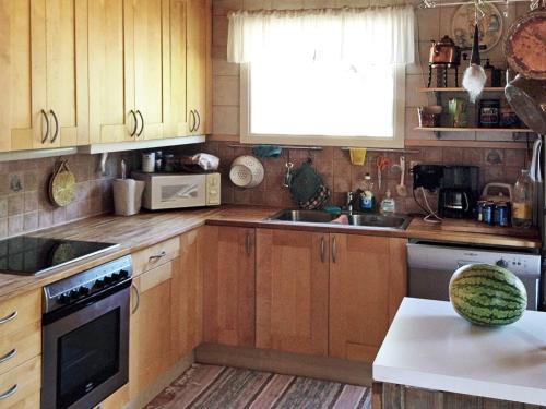 DalaröFour-Bedroom Holiday home in Dalarö的一个带木制橱柜和水槽的厨房