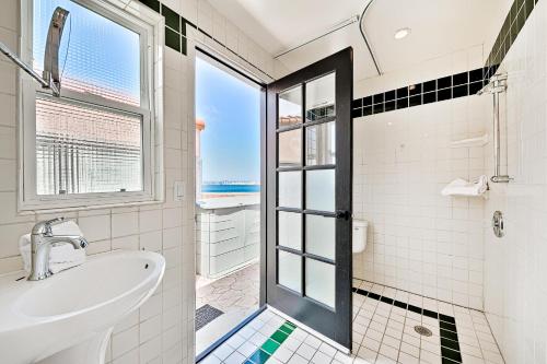圣地亚哥On The Beach Casa的一间带水槽和淋浴及窗户的浴室