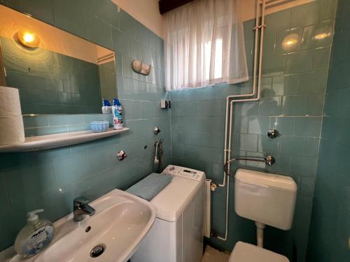 比克Noémi nyaralóház的一间带水槽、卫生间和镜子的浴室