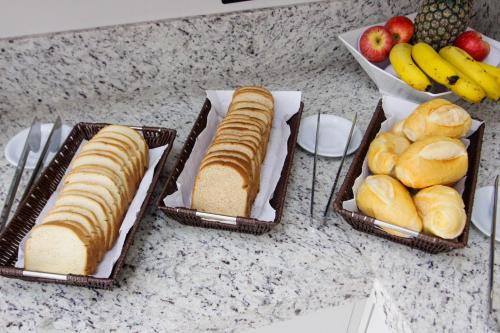 马林加NEO PARK HOTEL的柜台上三篮面包和水果