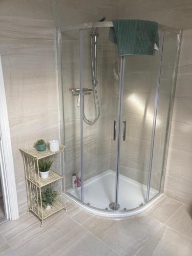 德罗赫达Alma’s retreat的浴室里设有玻璃门淋浴