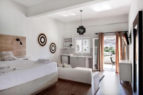 MérikhasCactus Suites Kythnos的一间白色卧室,配有一张大床和一个厨房
