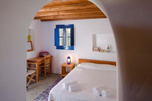 特里皮蒂Marketos Windmill and Houses的一间卧室配有一张床、一张书桌和一个窗户。