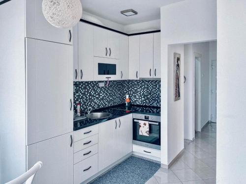 瓦列沃Buba Apartman的白色的厨房配有白色橱柜和炉灶。
