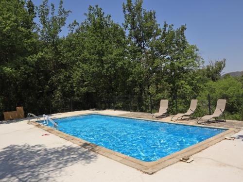 瓦劳里埃Gîte Nature et Calme du Travers的一个带两把椅子的大型游泳池