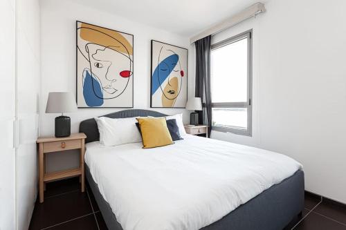 特拉维夫Luxury apartment with a great view的卧室配有白色的床,墙上挂有绘画作品