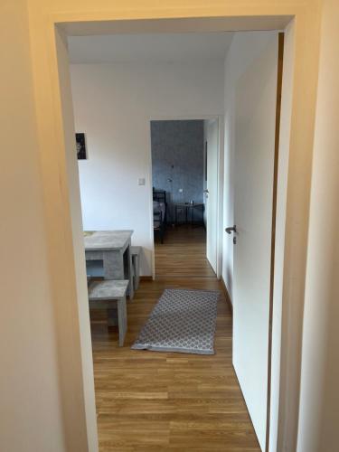 赖讷Schönes Appartement in Rheine Zentrumsnah的走廊通往带书桌和桌子的房间