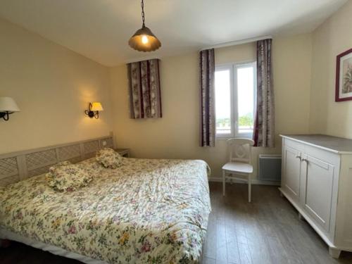 马莱莫尔Maison 3 pièces domaine golf Pont Royal的卧室配有床、椅子和窗户。