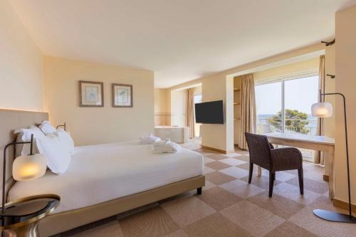 圣马克西姆Best Western Premier Montfleuri的酒店客房配有一张床、一张书桌和一台电视。