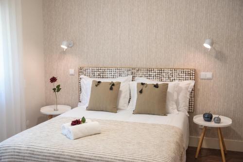 Cruz da LéguaRota VMF - Alcobaça的卧室配有一张带两张桌子的大型白色床