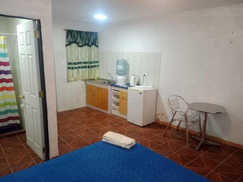 卡拉马Habitación cerca aeropuerto的一间小厨房,配有桌子和蓝色的地板