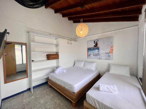 麦德林Hostal Casa Guadalupe的白色墙壁客房的两张床