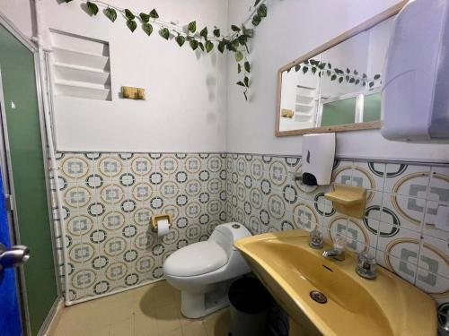 麦德林Hostal Casa Guadalupe的一间带水槽、卫生间和镜子的浴室