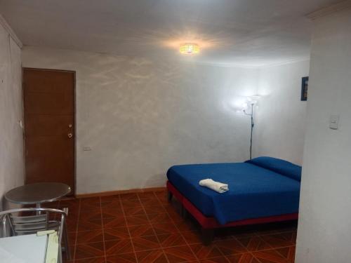 卡拉马Habitación sol naciente peuco的一间卧室配有蓝色的床和凳子