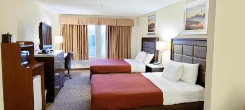 蒙哥马利如家旅馆&套房酒店的酒店客房设有两张床、一张桌子和一台电视。