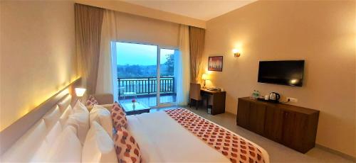贡珀尔格尔Kumbhal Exotica Resort Kumbhalgarh的酒店客房设有一张床和一个大窗户