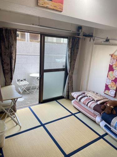 东京東洋の家-畳み部屋小庭園的配有床和滑动玻璃门的房间