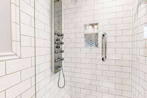 基韦斯特Seagrass Suite的浴室内铺有白色瓷砖并配有镜子的淋浴间