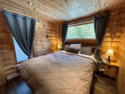拉马巴耶WOODY - Chalets de Môh的小木屋内一间卧室,配有一张床